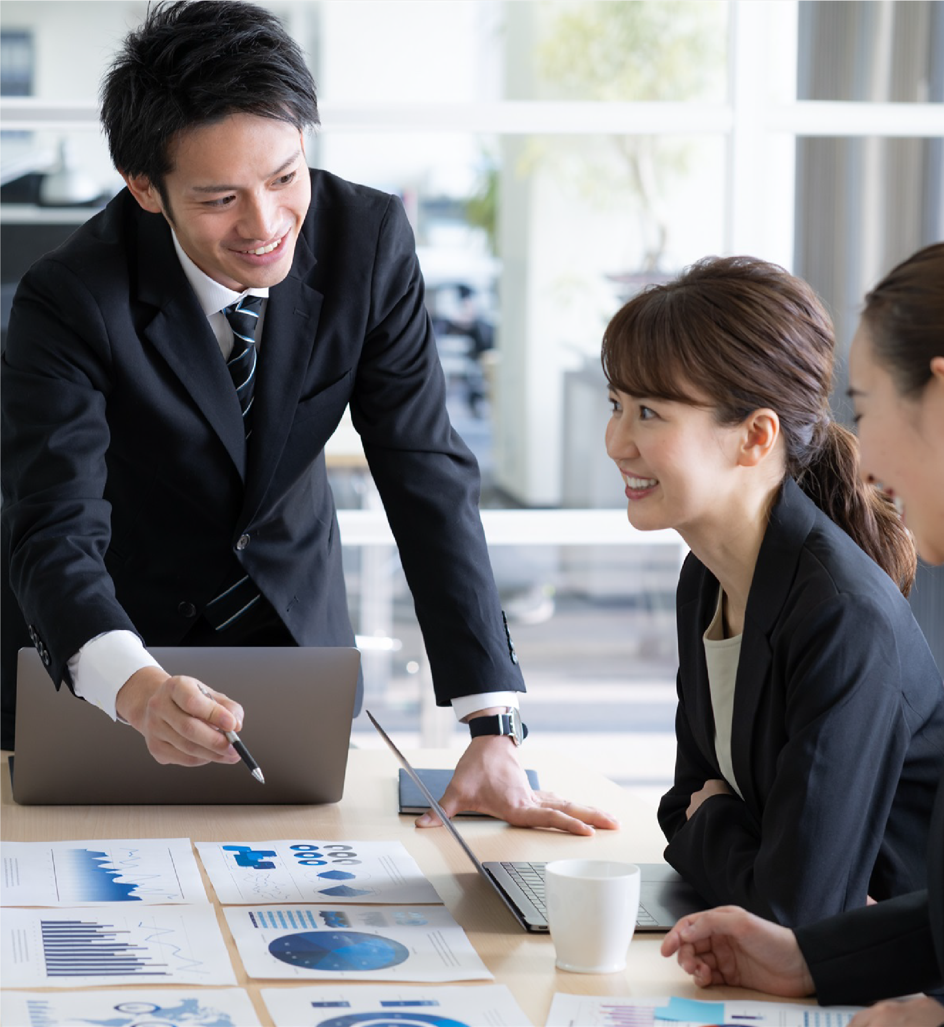 男性が資料を元に笑顔で女性たちに説明をしている写真